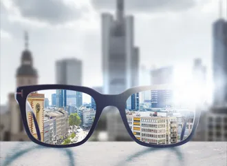 Brille auf einem Flachdach, die eine Vergrößerung der Frankfurter Stadt zeigt