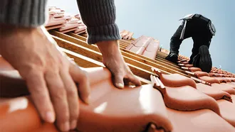 Dachhandwerker mit Braas Dachpfannen.
