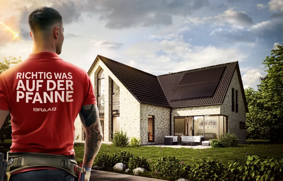 Dachdecker steht vor einem Haus im Abendlicht